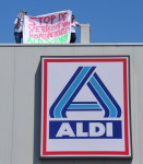 Op het spandoek die activisten vasthouden, staat te lezen 'stop de verkoop van konijnenvlees, Aldi schande!'